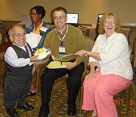 Robert Van Etten presents Todd and Kathleen with a large trackball, symbol of the SIG-11 office